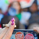 UNA MUJER toma una foto en una protesta contra los desahucios en Cataluña