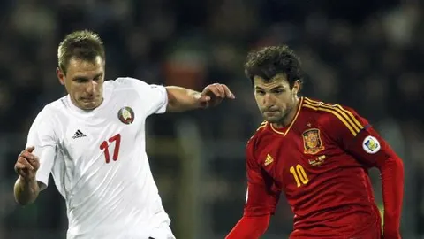 El jugador de España Cesc Fabregas (d) disputa el balón con Yan Tigorev de Bielorrusia