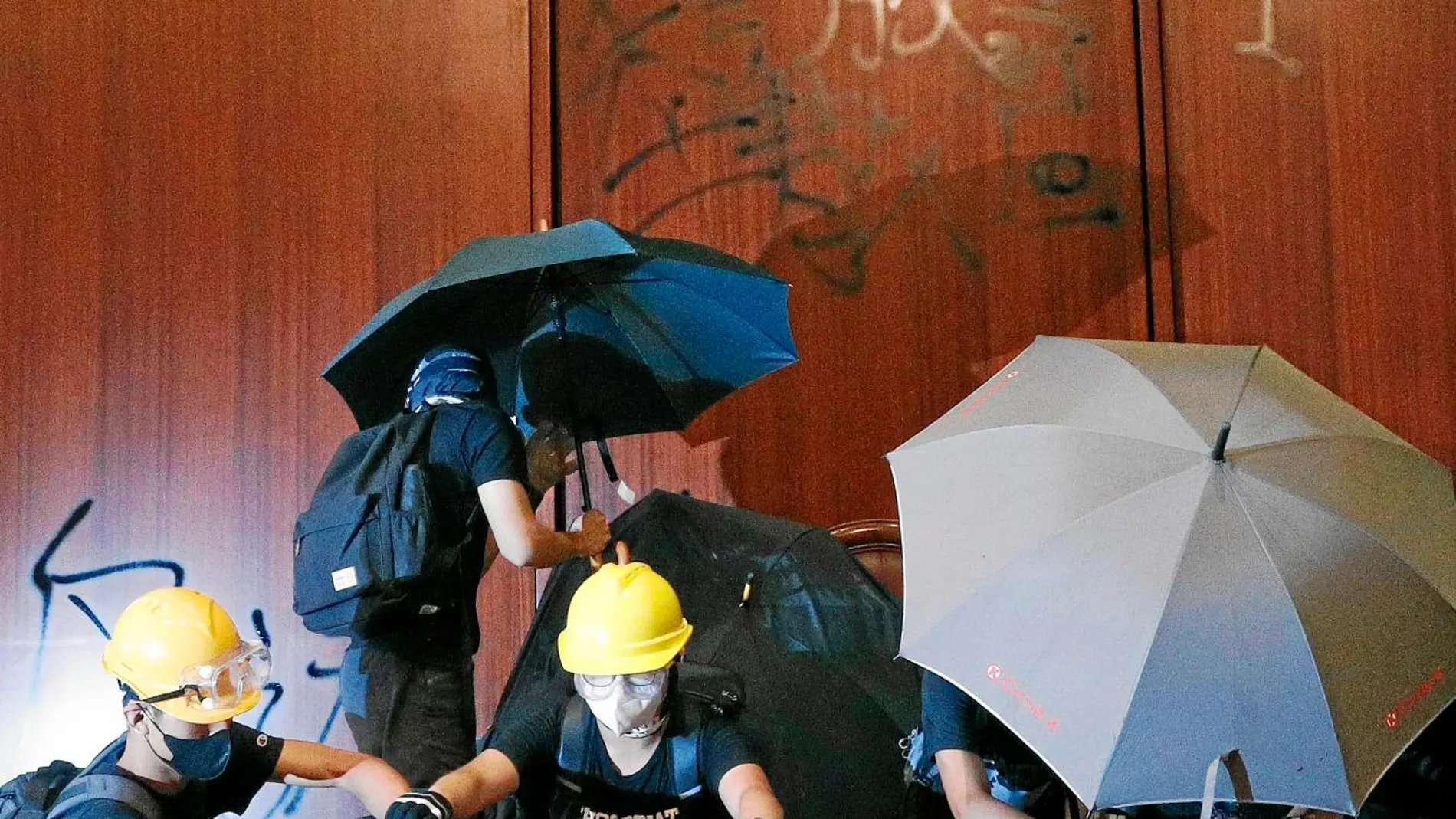 Un grupo de manifestantes coloca una bandera colonial en el Parlamento hongkonés / Ap