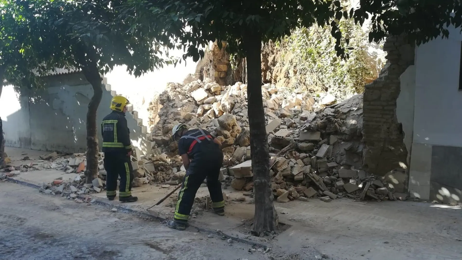 Dos bomberos junto al muro moderno y el trozo de muralla romana afectados por el derrumbe en la calle San Fernando de Córdoba / La Razón
