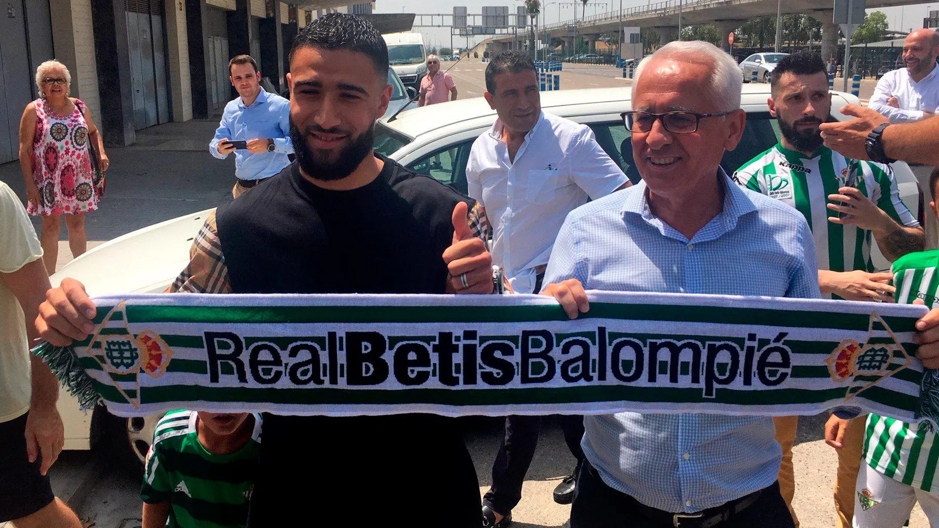 El centrocampista internacional del Olympique de Lyon francés Nabit Fekir, junto al director general del Betis, Federico Martínez Feria (d), sostiene una bufanda del club verdiblanco a su llegada hoy a Sevilla