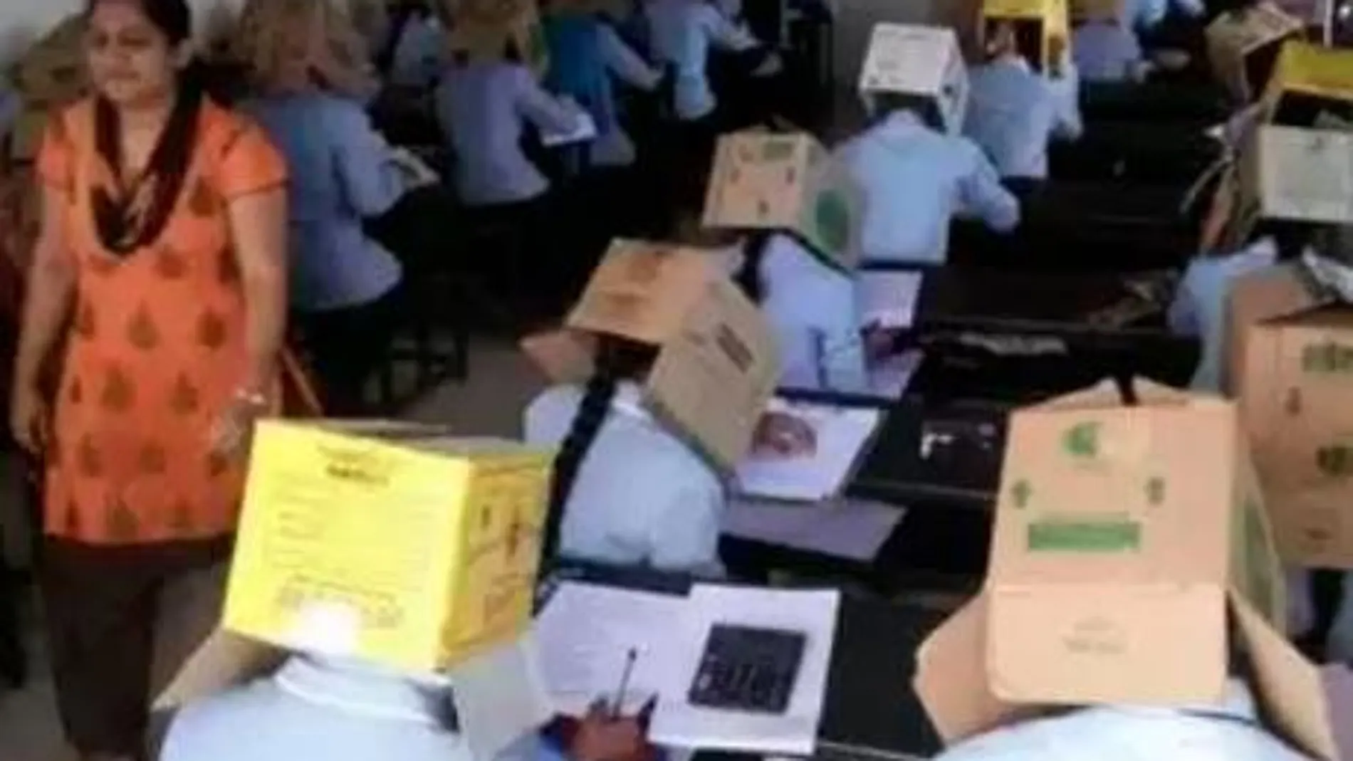 Imagen de los estudiantes con cajas en sus cabezas difundida en redes sociales.