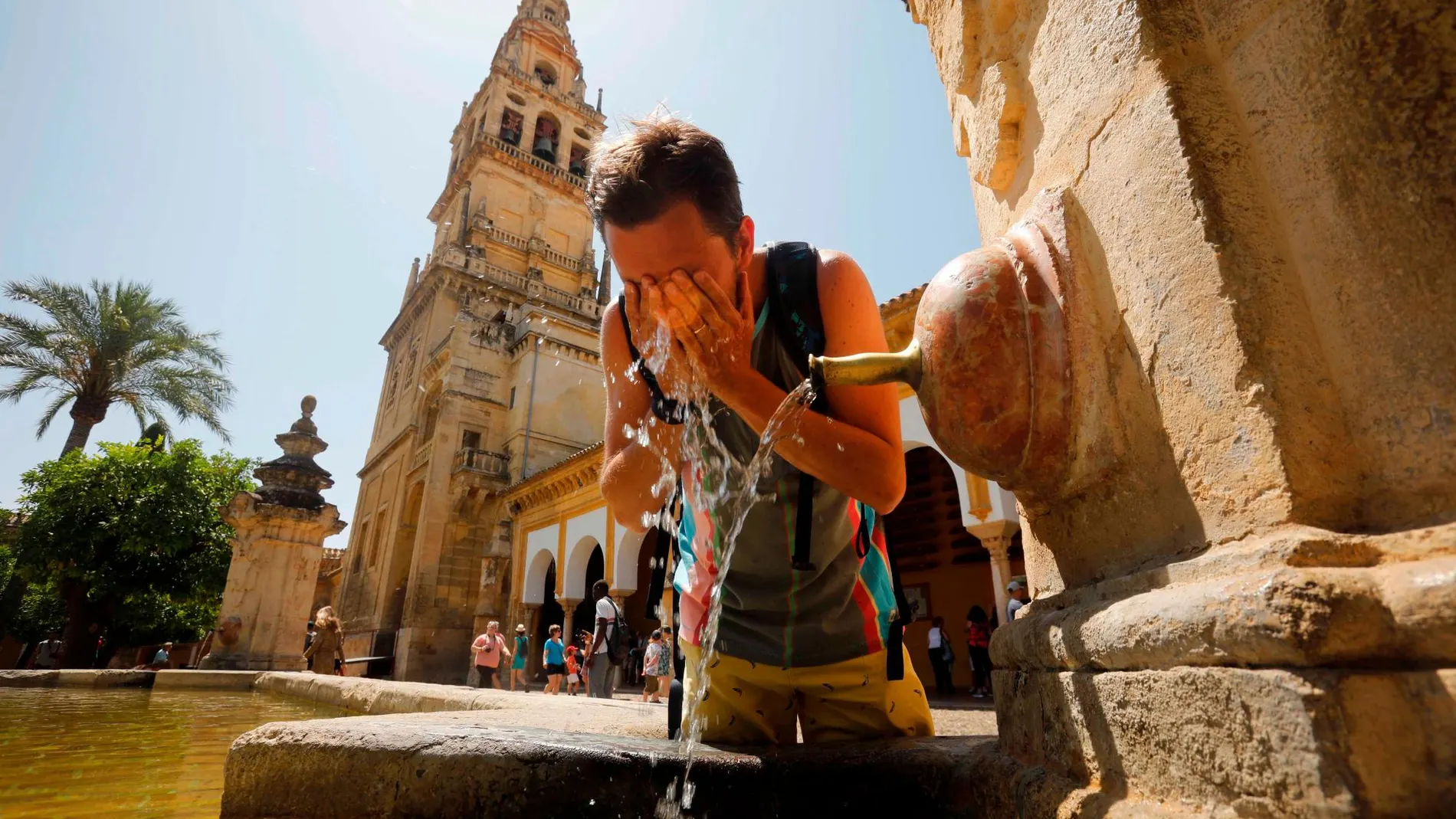 Un turista se refresca en una de las fuentes del patio de los Naranjos de la Mezquita-Catedral de Córdoba, ayer cuando las temperaturas máximas continúan en ascenso en Andalucía