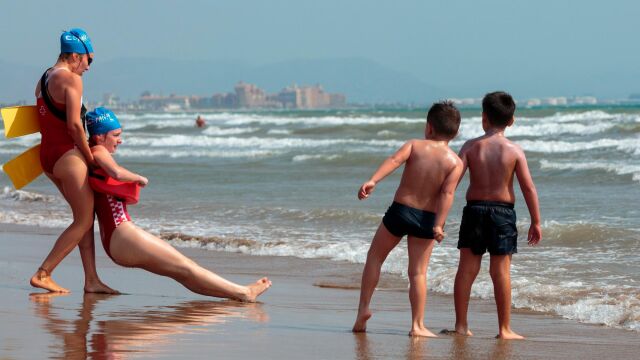 Unos socorristas realizan un simulacro de rescate en la playa de la Malvarrosa de Valencia, organizados por Cruz Roja y la Federación Española de Salvamento y Socorrismo