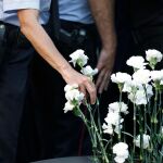 Miembros de los Mossos d’Esquadra colocando claveles blancos en honor a las víctimas