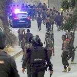 Agentes de la policía corren tras los inmigrantes tras la entrada en Ceuta. El salto a la valla fue uno de los más violentos y el primero desde el mes de agosto del año pasado