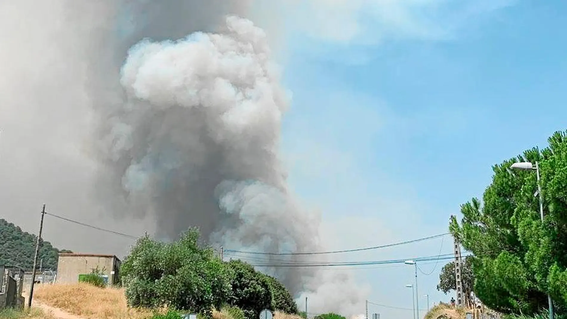 Varios vecinos observan una columna de humo en el municipio de Cenicientos