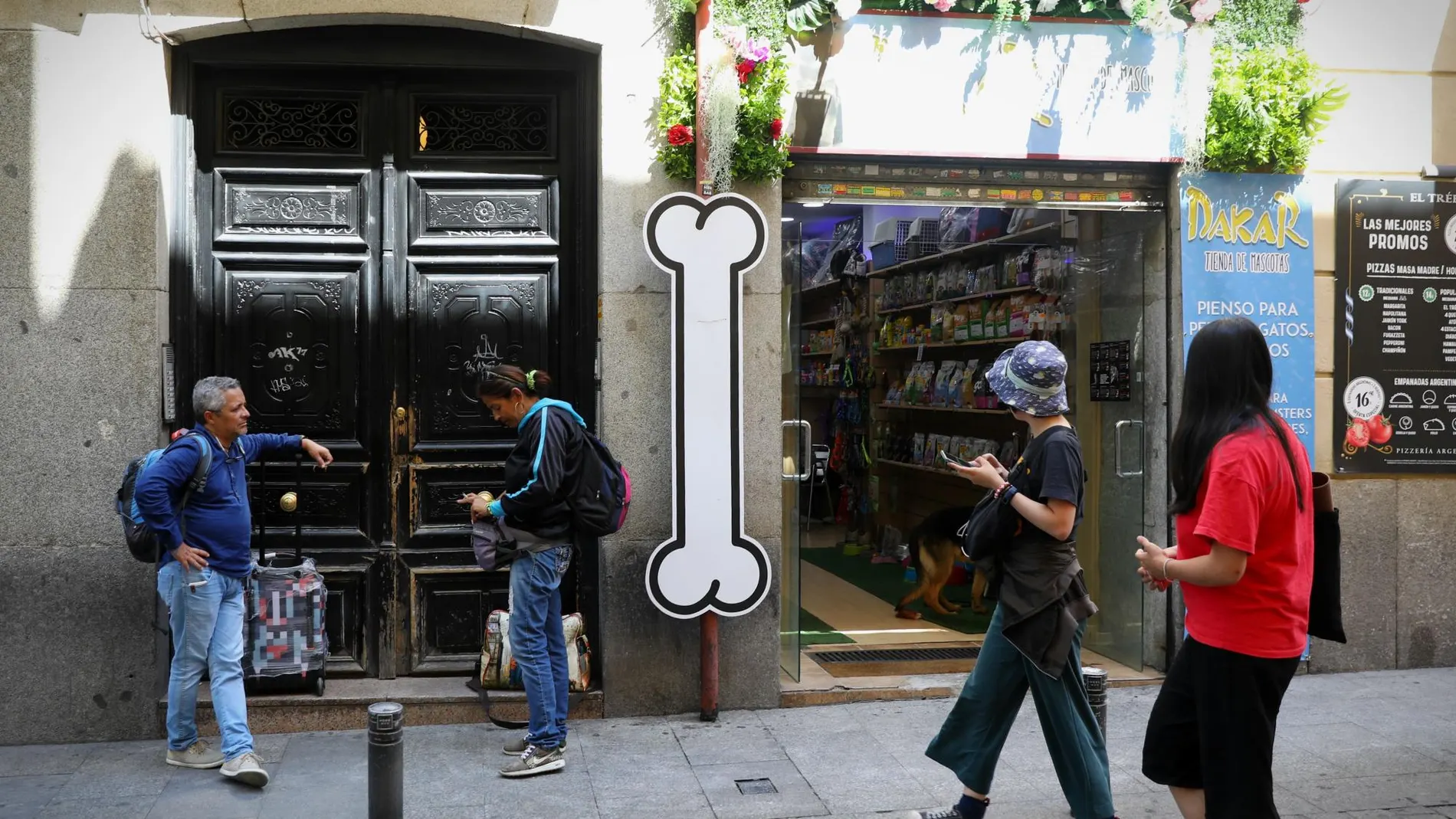 Unos turistas esperan en la entrada de una vivienda en Madrid