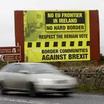 Un vehículo circula por una carretera entre Irlanda y el Ulster con un cartel contrario a una “frontera dura” tras el Brexit