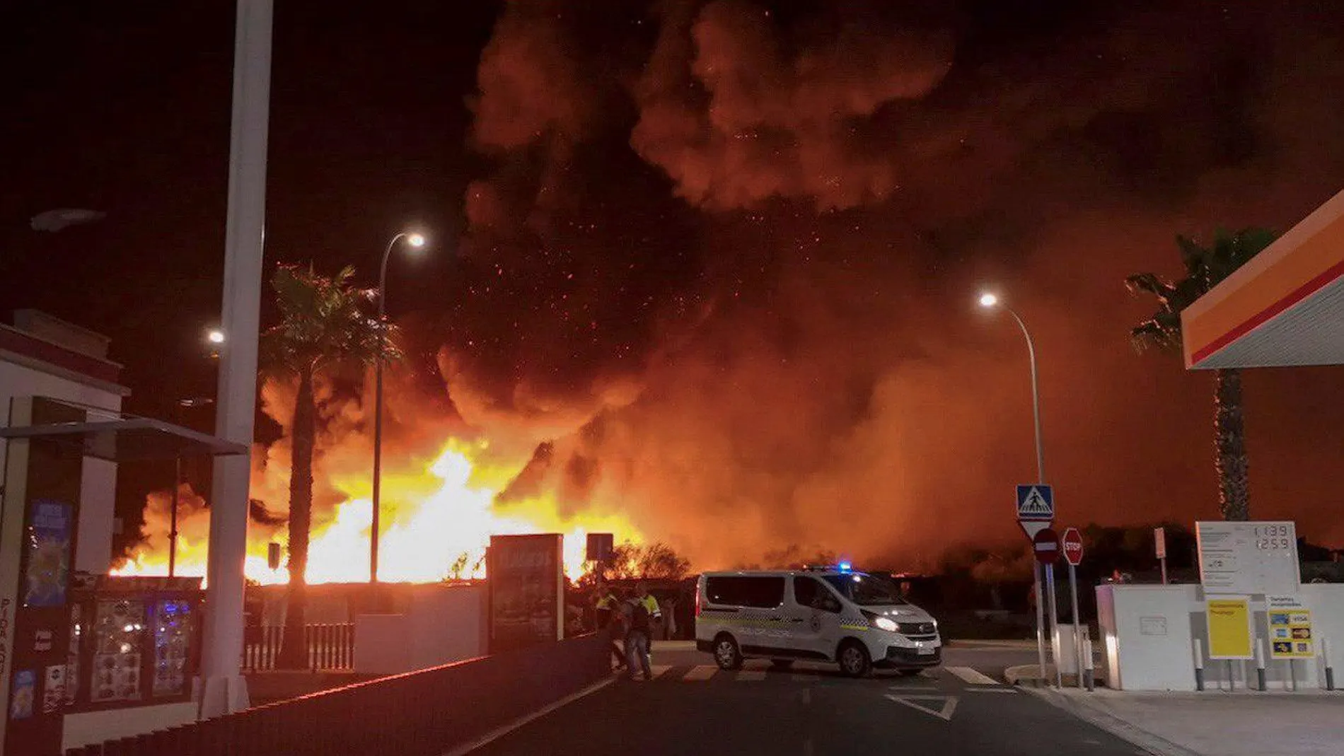 Imagen de las llamas producidas por el incendio que se ha originado poco antes de las diez de la noche en el asentamiento de inmigrantes ubicado junto al cementerio de Lepe, y que ha obligado a desalojarlo por completo / Efe