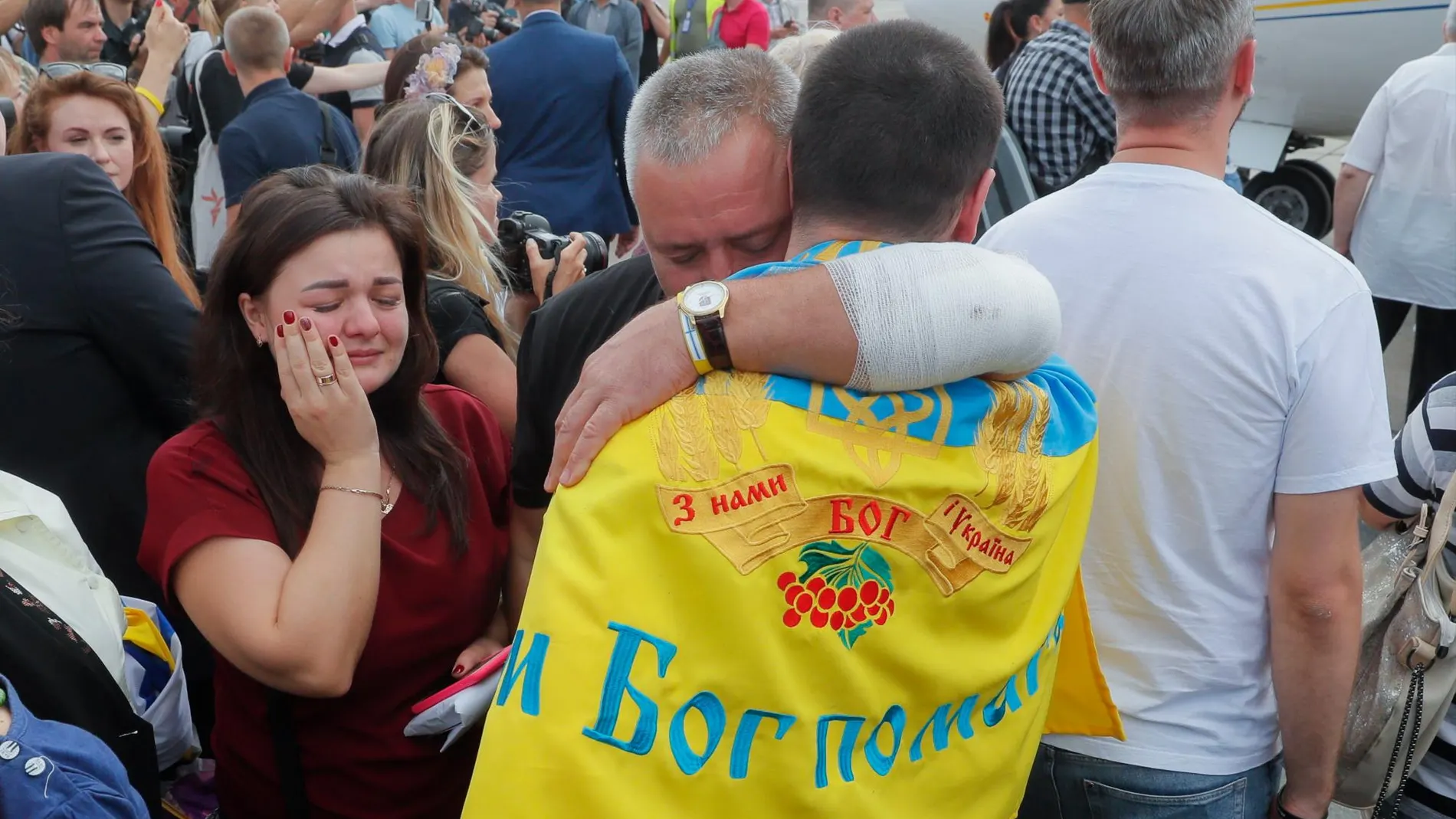 Familiares y periodistas rodean a los prisioneros liberados tras aterrizar en Kiev/Efe
