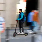 Hombre conduciendo un patinete eléctrico por la calle