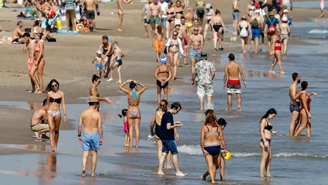 Vecinos y turistas disfrutan de la playa de la Malvarrosa