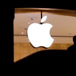 Un hombre mientras pasa junto al símbolo de Apple / Foto: Efe