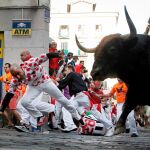 Los toros de la ganadería de La Palmosilla, de Tarifa (Cádiz), a su paso por la curva de la calle de Mercaderes, durante el séptimo encierro de los Sanfermines 2019