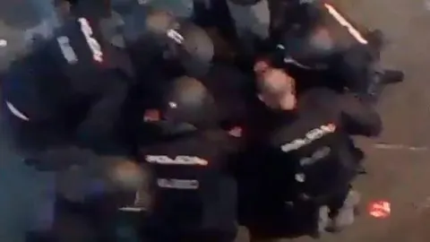 Imagen tomada del vídeo en la que se ven a los agentes atendiendo a su compañero herido.