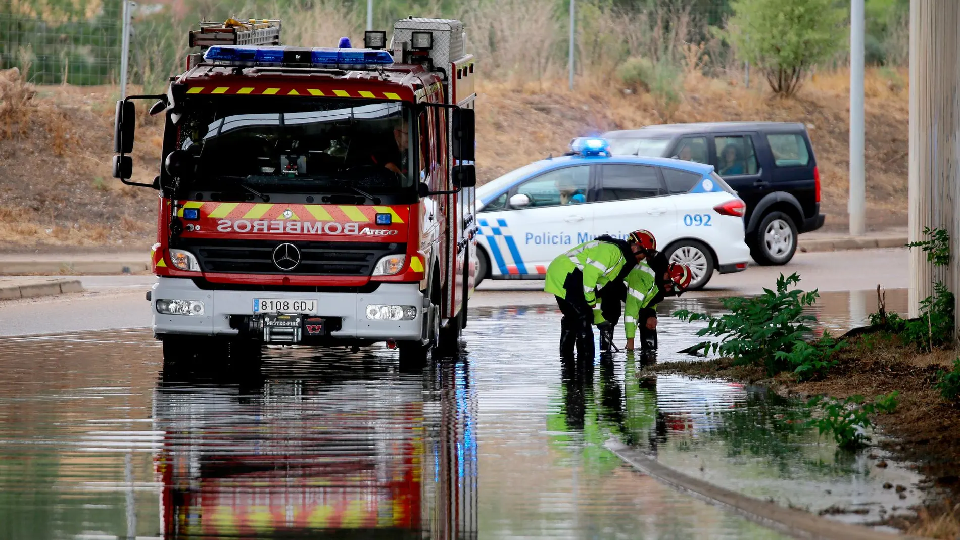 Los bomberos trabajan limpiando una zona de la VA-30 inundada por las fuertes lluvias
