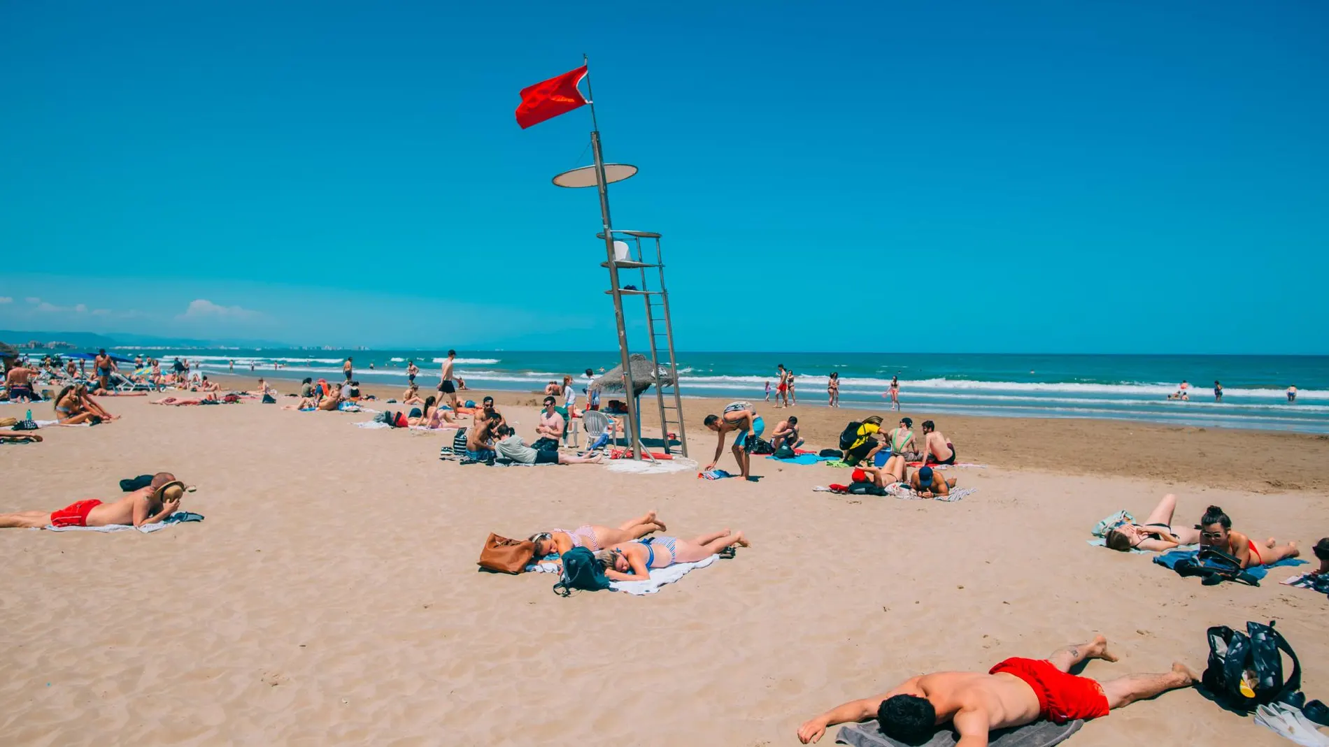 Un grupo de jóvenes toma el sol en la playa de la Malvarrosa de Valencia. Los dermatólogos aconsejan ponerse crema cada dos horas como máximo para evitar quemaduras