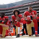 Colin Kaepernick, exquaterback de los San Francisco 49ers (centro), se arrodilla durante el himno nacional de EEUU como protesta contra el racismo en el país