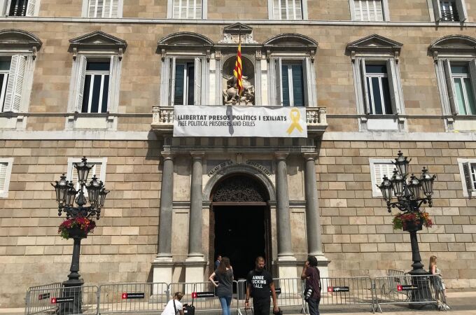 Vista del cartel reclamando la libertad de los líderes independentistas presos y un lazo amarillo en la fachada del Palau de la Generalitat
