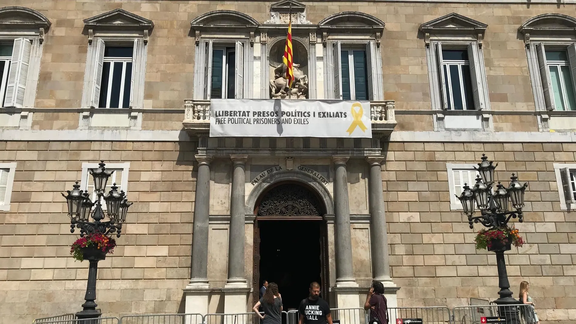 Vista del cartel reclamando la libertad de los líderes independentistas presos y un lazo amarillo en la fachada del Palau de la Generalitat