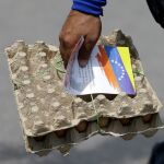 Un hombre con un cartón de huevos en Caracas en una foto de archivo/AP