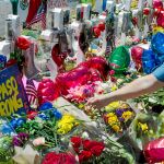 Una mujer deposita una flor en el memorial por las víctimas del ataque terrorista perpetrado por Patrick Crusius hace una semana