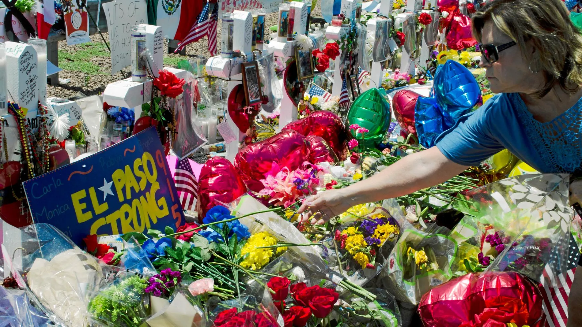 Una mujer deposita una flor en el memorial por las víctimas del ataque terrorista perpetrado por Patrick Crusius hace una semana