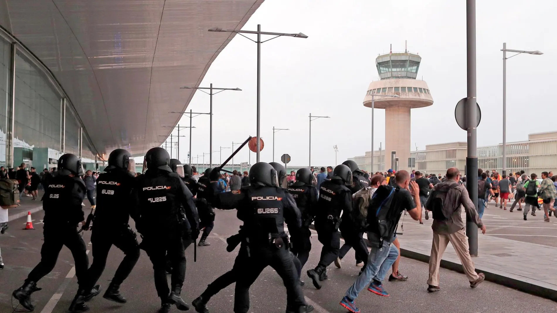 Miembros de la Policía Nacional cargan contra los centenares de personas que se agolpan ante el Aeropuerto del Prat. EFE/Alejandro García