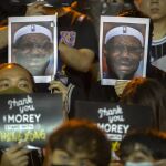 Manifestantes muestran fotos de LeBron James durante su marcha en Hong Kong.