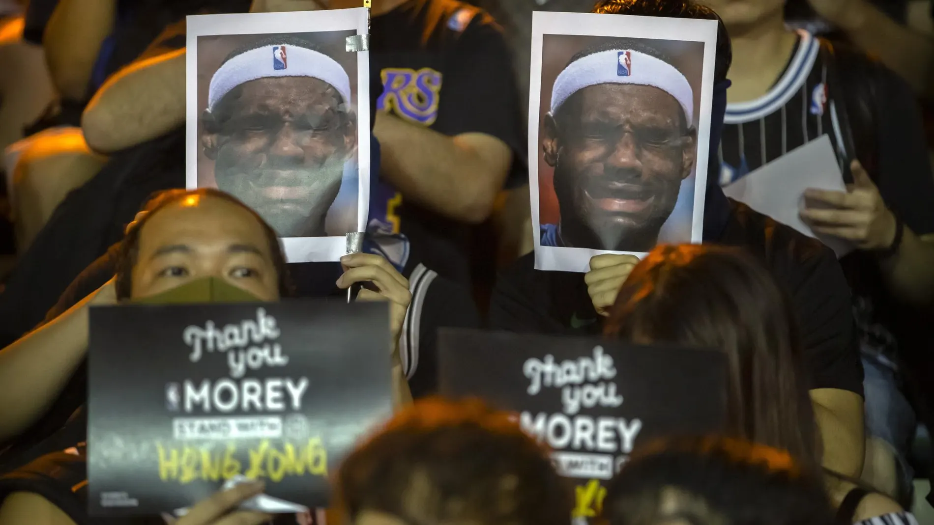 Manifestantes muestran fotos de LeBron James durante su marcha en Hong Kong.