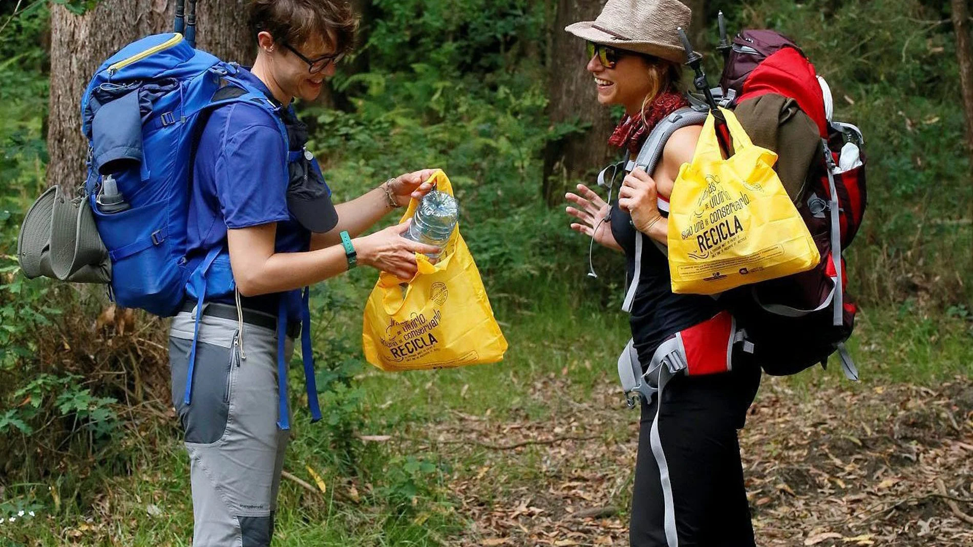 Dos peregrinas utilizan las bolsas de reciclaje en el Camino de Santiago