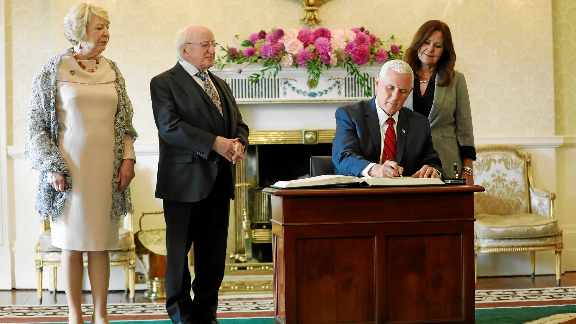 El vicepresidente de EE UU, Mike Pence, firma en el libro de honor del palacio del presidente irlandés, ayer en Dublín