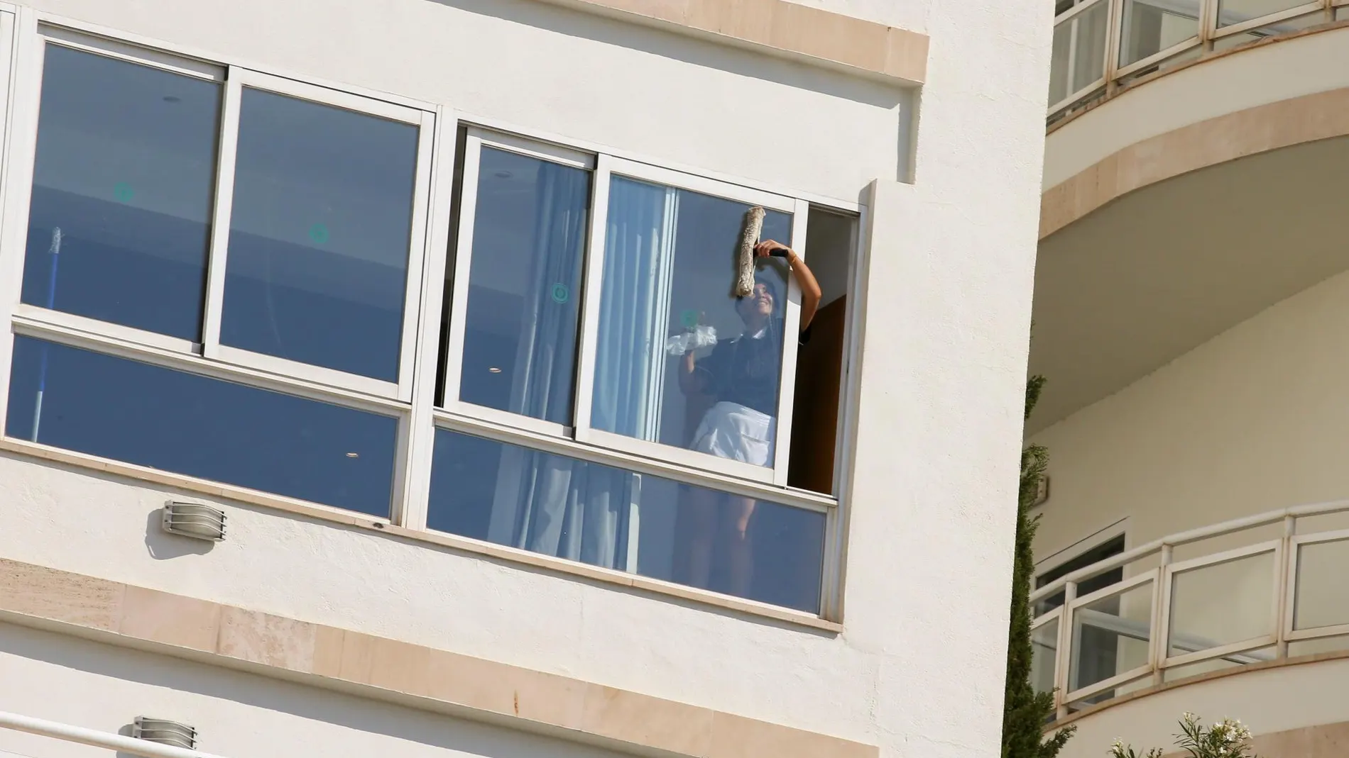 Una empleada limpia la ventana de un hotel en Palma de Mallorca