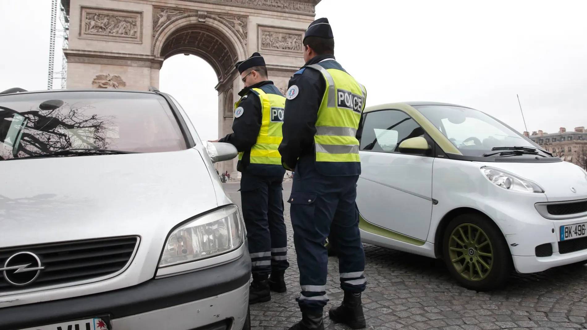 La policía francesa para dos coche frente al Arco del Triunfo, en París