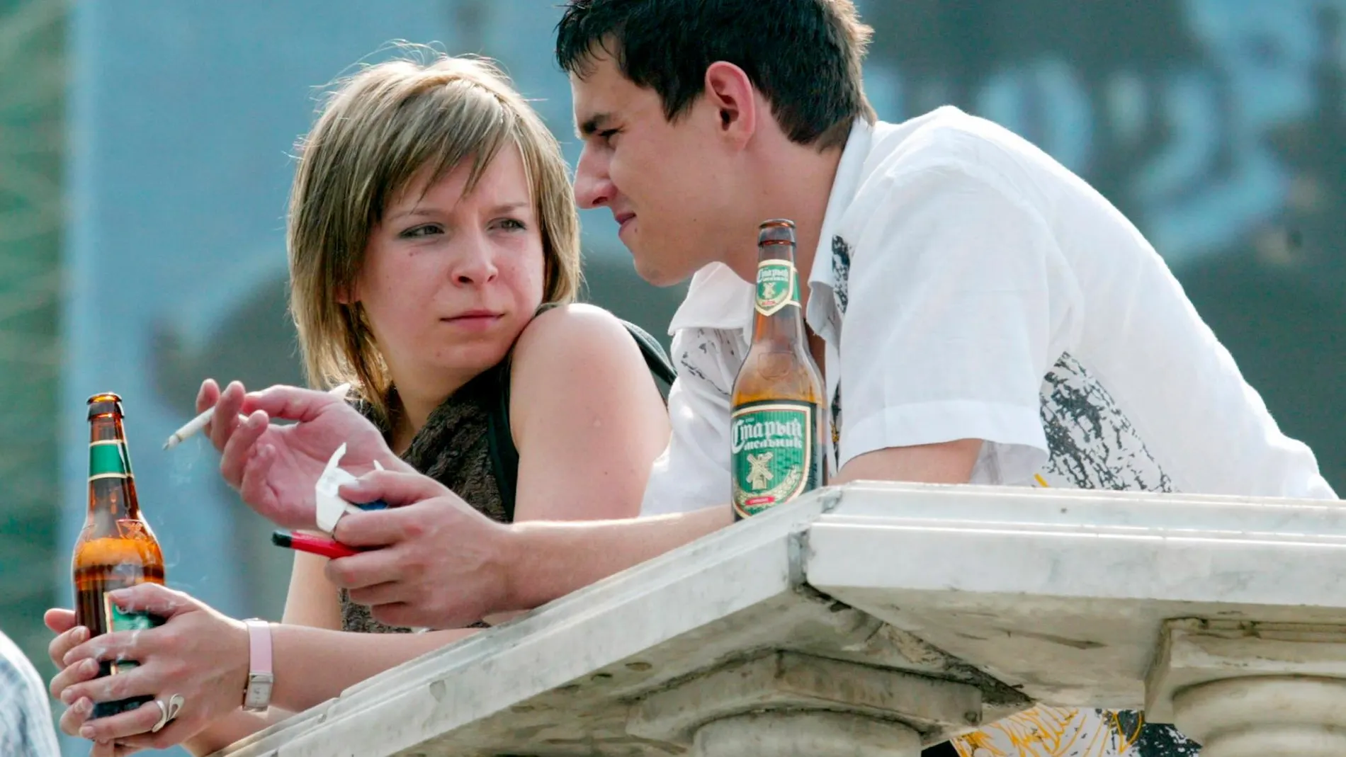 Unos jóvenes beben y fuman en una terraza