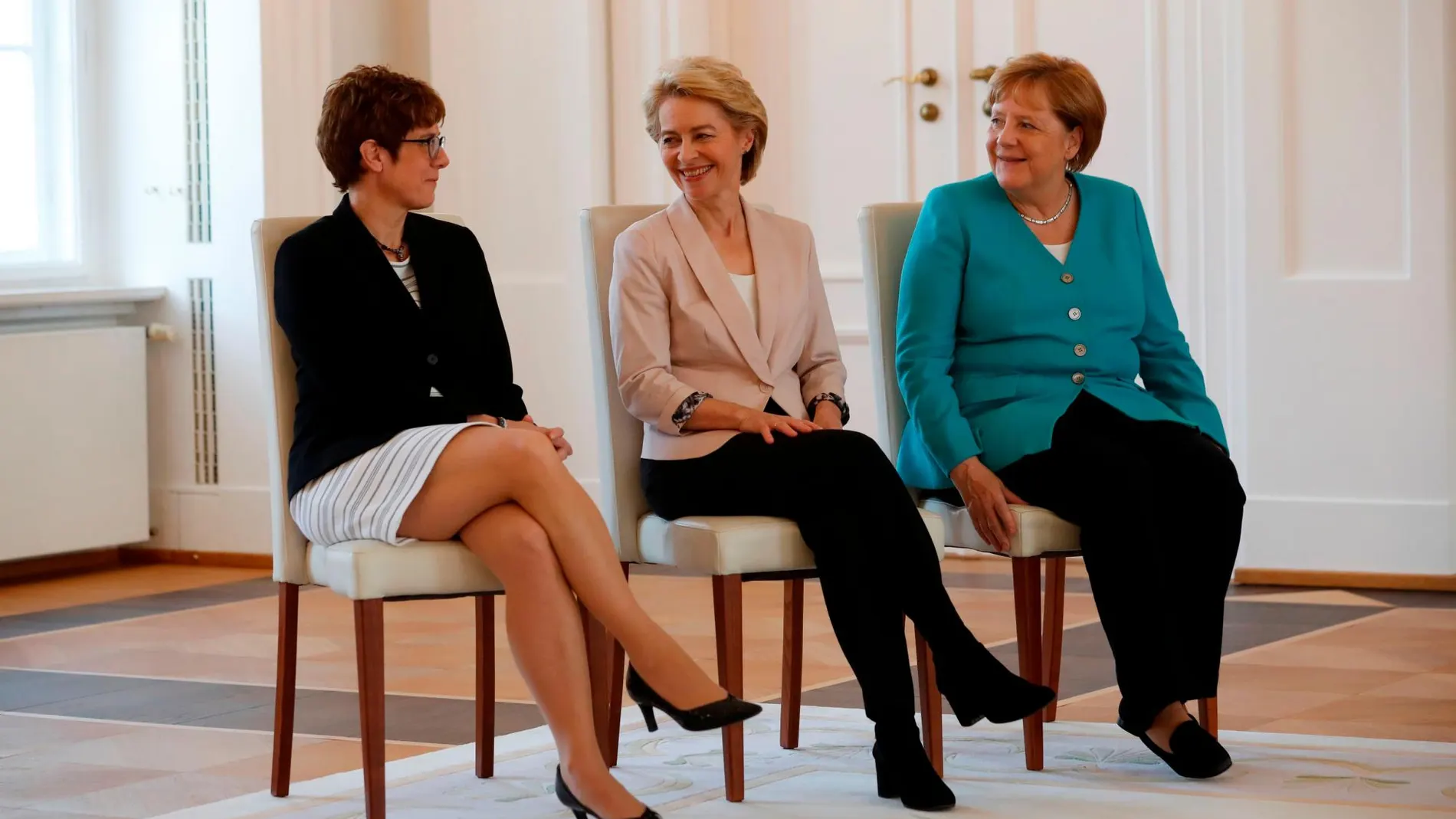 Ursula von der Leyen entre Annegret Kramp-Karrenbauer y la canciller Angela Merkel permanecieron sentadas buena parte del acto de traspaso de cartera/Reuters