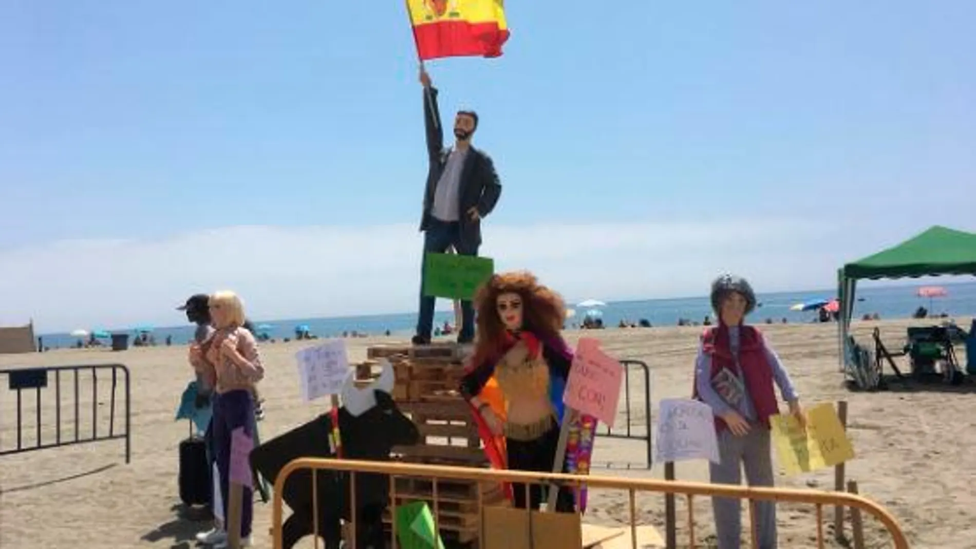 Figura de Santiago Abascal ondeando la bandera de España, sobre una montaña de palés de madera / Twitter