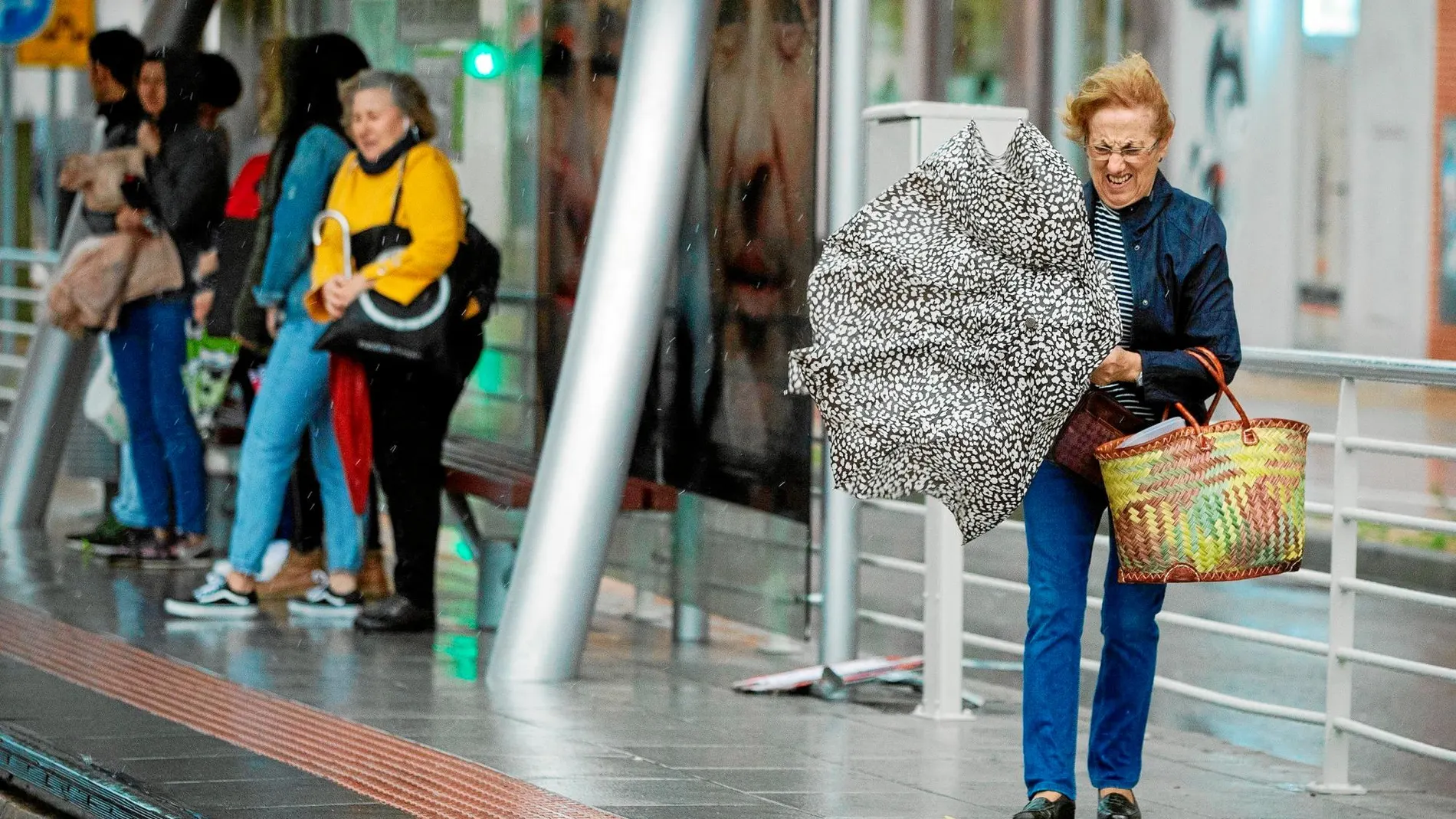 Una mujer lucha por conseguir abrir su paraguas, ayer, en Castellón de la Plana / Efe