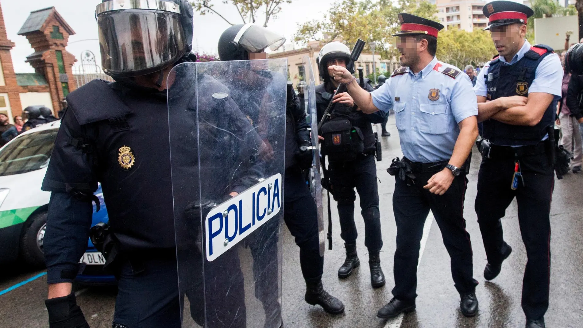 Agentes antidisturbios de la Policía Nacional y de los Mossos d' Esquadra discuten frente a un instituto catalán en septiembre de 2017 / Foto: Efe