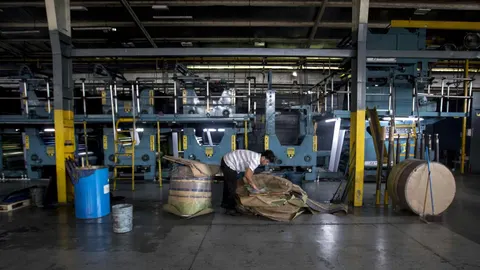 Un hombre trabaja en la rotativo de un periódico