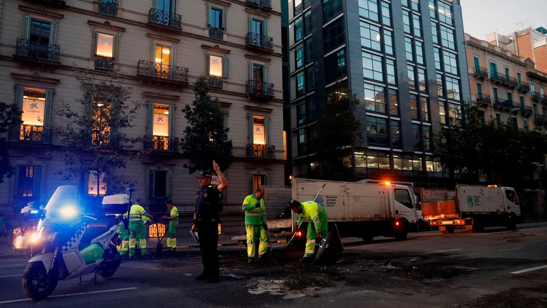 Operarios limpian las calles de Barcelona tras los altercados del martes