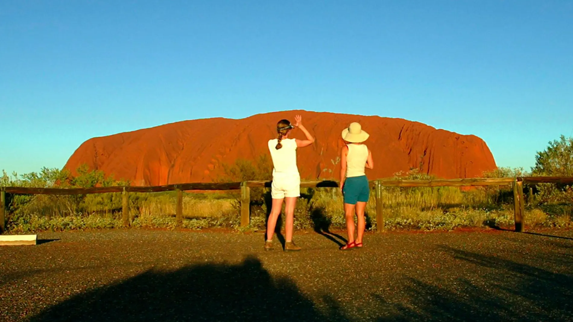 Dos turistas observan la imponente Ayers Rock, en Australia / Tim Wimborne