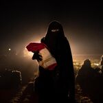 Una mujer y su bebé evacuados de territorio tomado por el Estado Islámico/Ap