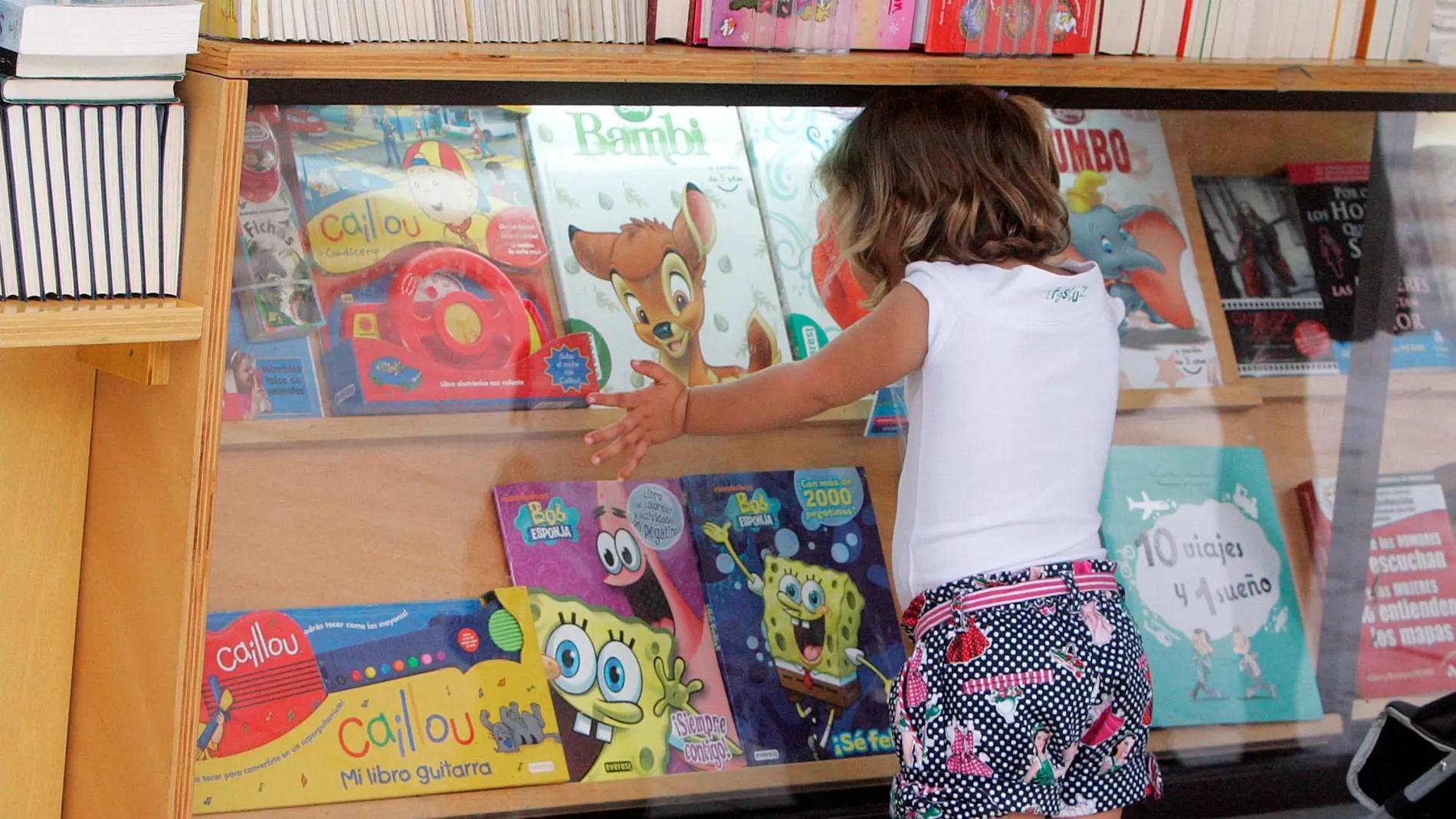 Una niña elige el próximo libro que se va a leer / Manolo Olmedo