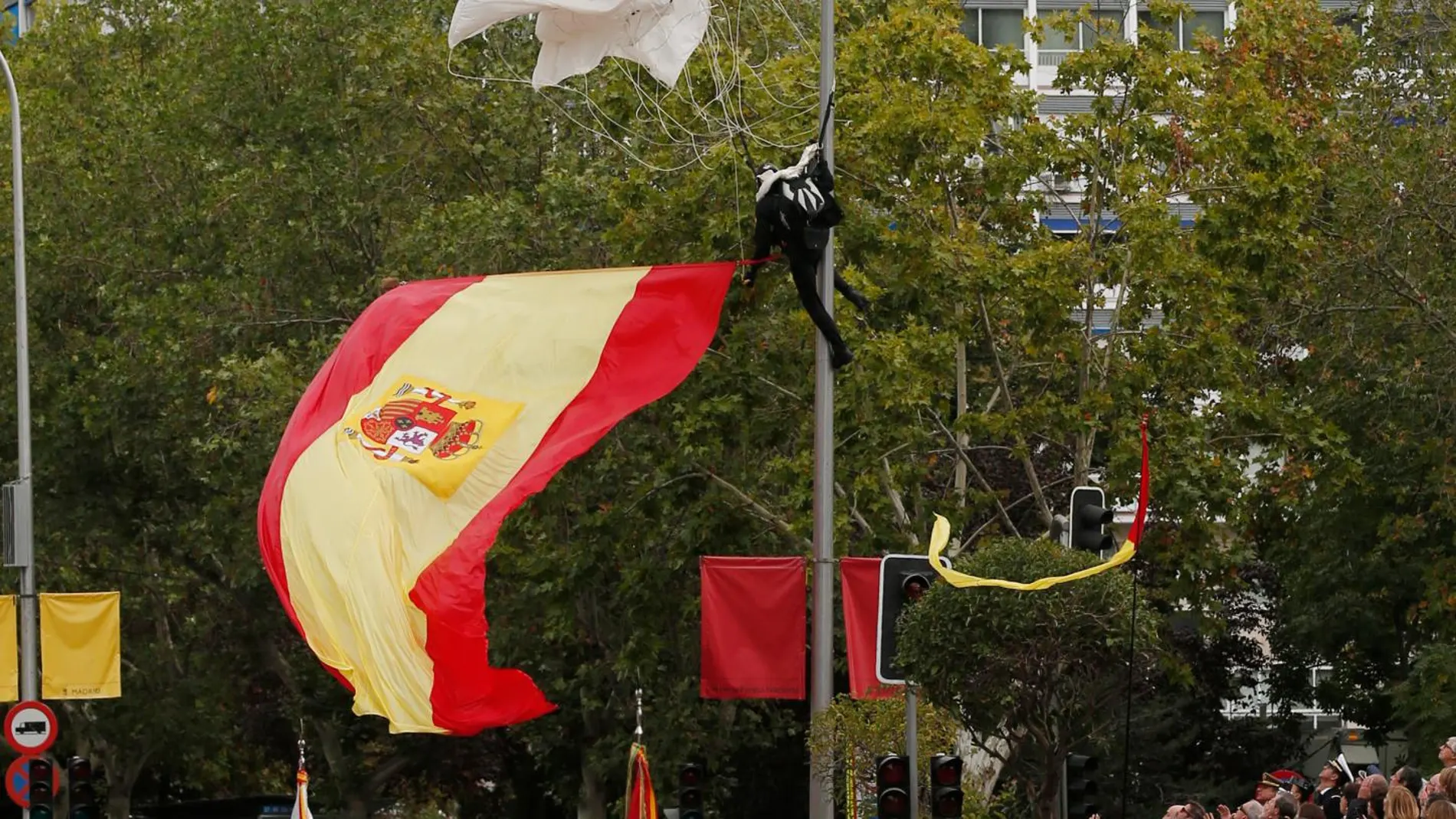 Un paracaidista que descendía con la bandera de España se ha quedado enganchado de una farola en el desfile del Día de la Fiesta Nacional/Foto: Jesús G. Feria