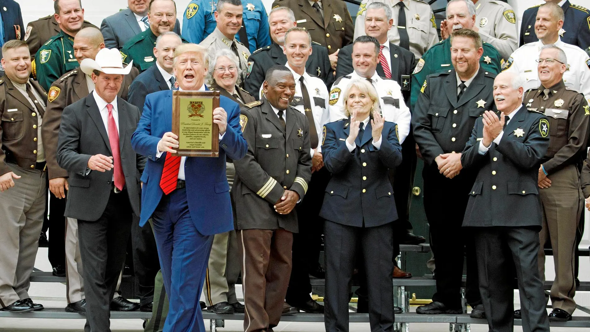 El presidente Donald Trump sostiene una placa honorífica entrega el jueve en la Casa Blanca por la Asociación de «sheriffs» de EE UU
