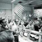 Los ingenieros de seguimiento de vuelo celebran el aterrizaje de la nave en el centro de control de Houston