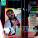 Un hombre es escoltado por la Policía en un autobús desde el cementerio y la sinagoga atacados, en Halle/ AP