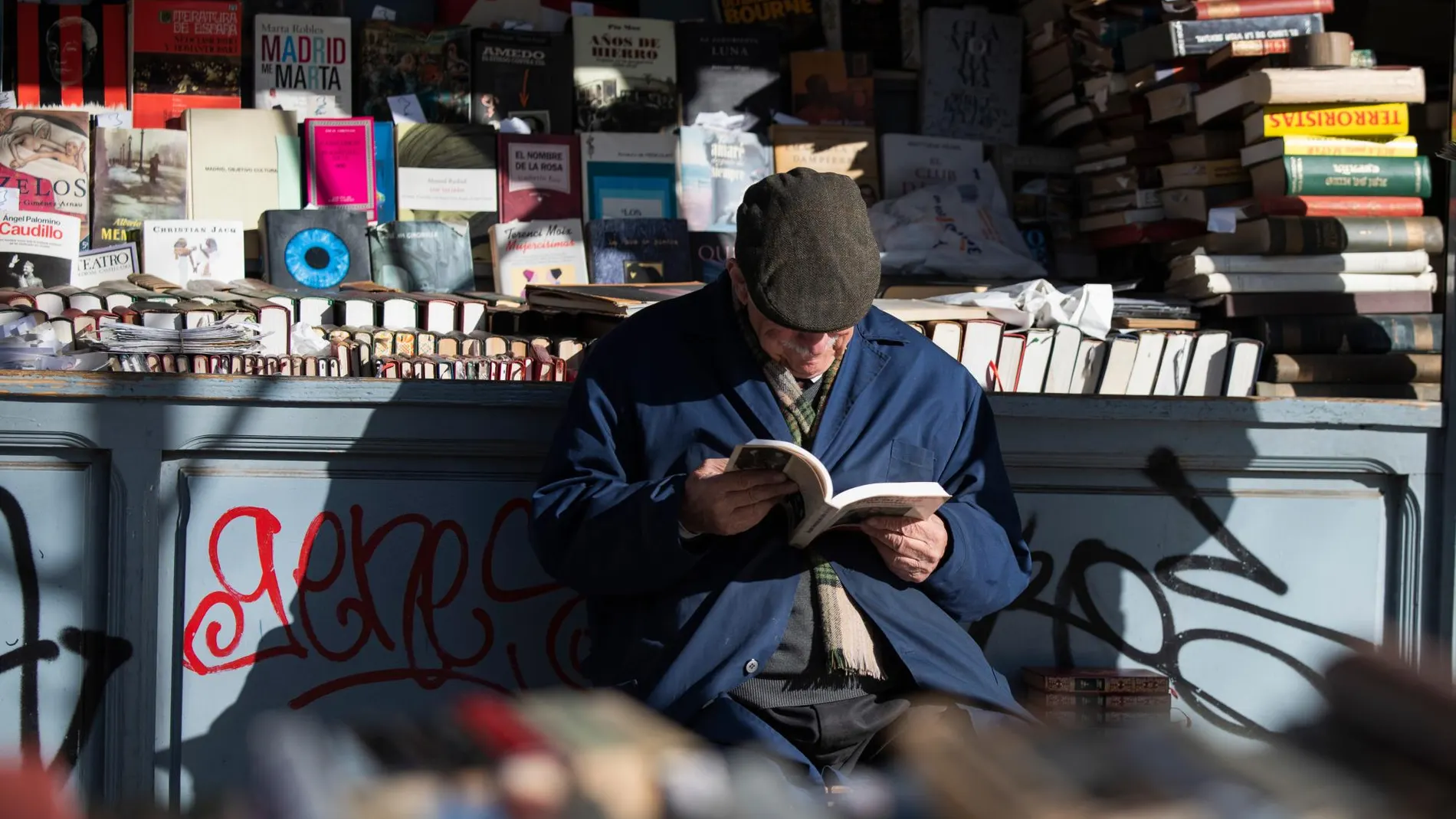 Imagen de archivo de un jubilado leyendo un libro en una feria dedicada a la literatura